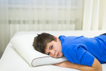 Fototapeta premium Boy teenager lying face down on anatomic pillow