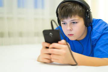 Teen using cell phone with headphones
