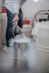 Liquid nitrogen technician fills cryogenic container