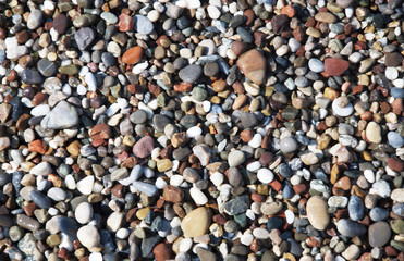 Wet shiny little pebbles sea