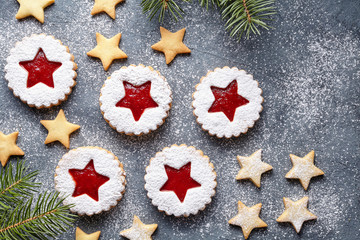 Assorted cookies. Christmas festive homemade ginger cookies star with strawberry jam. Flat lay. Shortcrust pastry. Traditional Austrian Linzer cookie on green background. Top view.