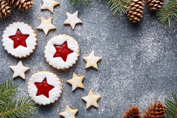 Round and star-like Christmas biscuitss ginger cookies with strawberry jam. Flat lay. Traditional Austrian christmas cookies - Linzer biscuits. Copy space. Festive decoration. Top view.