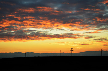 Fototapeta premium Dramatic sunset sky with mountain silhouettes