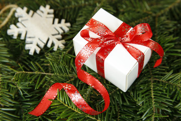christmas present on fir tree with decorative ribbon
