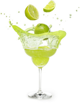 lime falling into a margarita cocktail splashing isolated on white