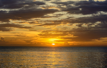 Sunset sky with gold background at te sky line on the sea