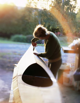 Boat builder working on a stich and glue kayak, Washington State, USA