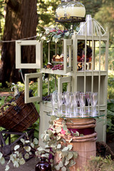 Candy bar with cupcake, macaroon, lemonade near barrel with empty glasses for champagne