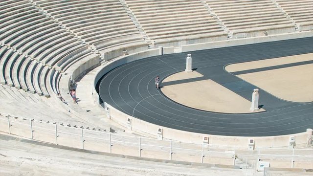 Athens Greece Panathenaic Stadium Close-up with Visiting Tourist Running Around the Ancient Historical Olympic Venue Track