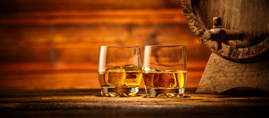 Glazen whisky met ijsblokjes geserveerd op hout
