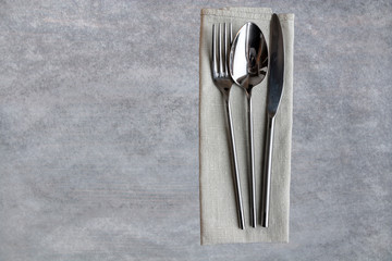 Concept of simple organic food - laconic design cutlery set on linen tissue and texture background. Copy space.
