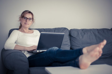 Middle-aged woman using laptop at home 