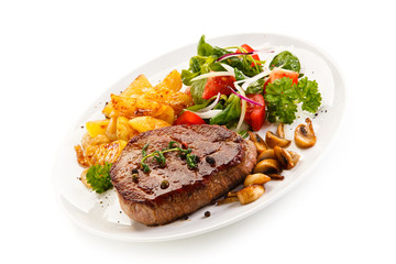 Grilled steak, baked potatoes and vegetable salad on white background 