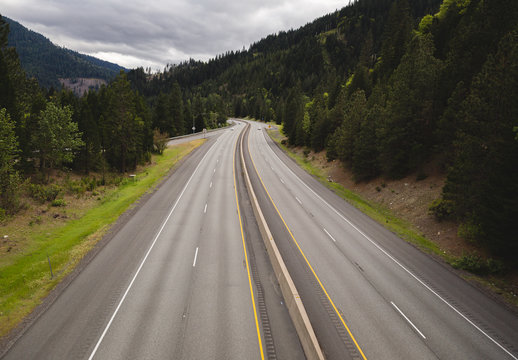 Interstate highway with four lanes and divider in lush Pacific Northwest USA setting.
