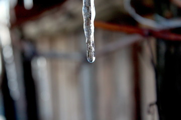 Icicle hanging from rooftop, winter scene