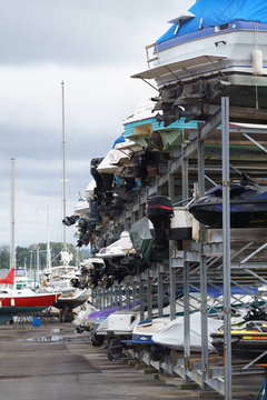 Backs of rows of boats from side, in storage on land
