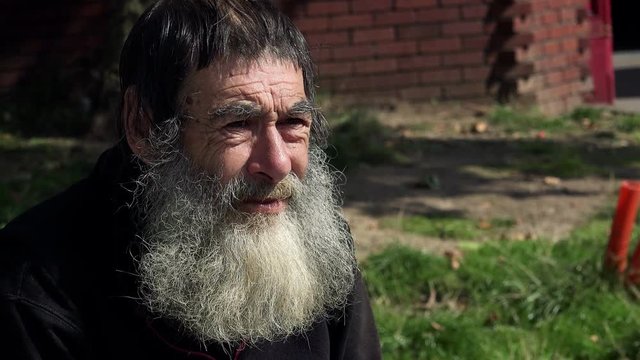 living on the streets by begging: old ill and dirty man portrait, homeless 