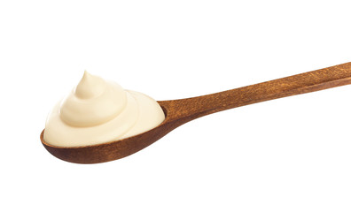 Sour cream in wooden spoon isolated on white background