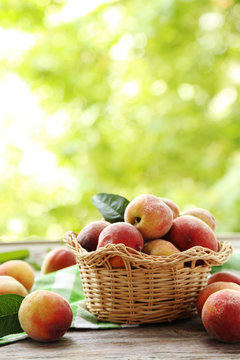 Sweet Peach Fruit In Basket On Grey Wooden Table