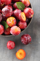 Fresh plums on a grey wooden table