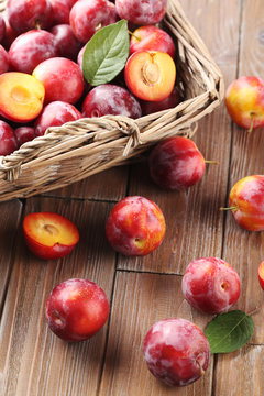Fresh plums on a brown wooden table