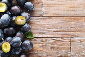 Tasty and ripe plums on brown wooden table