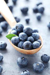 Ripe and tasty blueberries on grey wooden table