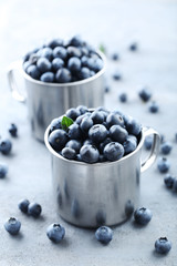 Ripe and tasty blueberries on grey wooden table
