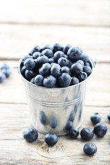 Ripe and tasty blueberries on grey wooden table
