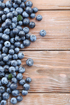 Ripe and tasty blueberries on brown wooden table