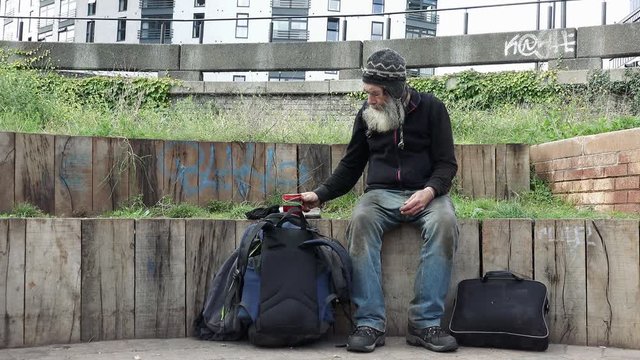 abandoned and rejected old man drinking hot tea in the street: homeless life