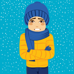 Man shivering in cold winter outdoors wearing warm clothes on snowy day