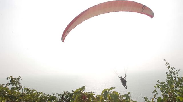Paragliding over the mountains and the ocean near the beach Kalach