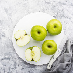 fashionable colors, the green apples on a gray marble table   white cutting board. Top view