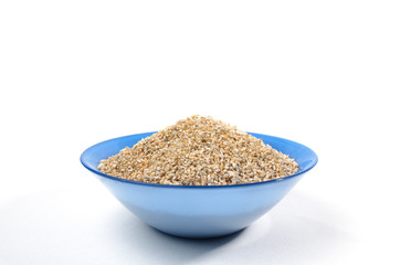Blue bowl of barley grits isolated on white