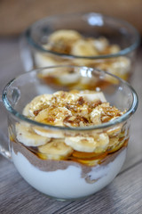 Granola with yogurt, bananas and whole walnuts, maple syrup clea