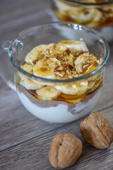 Granola with yogurt, bananas and whole walnuts, maple syrup clea