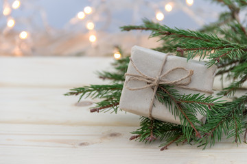 Fototapeta na wymiar Копозиция с еловой веткой , поздравлением и подарком к Рождеству и Новому году на деревянном фоне. Концепция международные празднования.