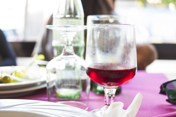 Red wine on a wineglass on busy restaurant table