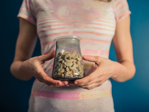 Young woman wih jar of cashew nuts