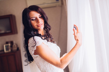 young bride with perfume is getting ready at home in the morning, wedding day 