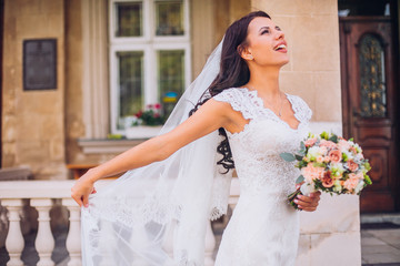 Fototapeta premium Portrait of cute Bride near the column with flowers