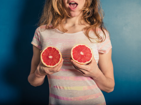 Young woman holding her grapefruits
