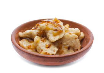 Cooked dishes of national Ukrainian dumplings with onion kitchen- lie in a clay plate.