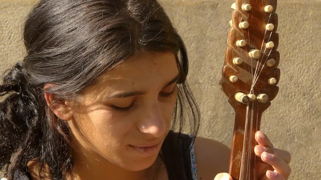 street artist playing an old string in the street 