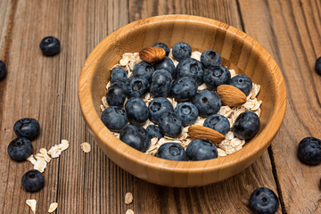 Healthy breakfast, oatmeal, honey  and fresh berries on rustic background. Fresh granola and musli.