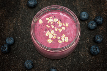 Obraz na płótnie Canvas Blueberry smoothie in a bowl on dark background