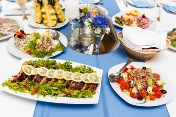 Fried fish and salads on a banquet table in restaurant