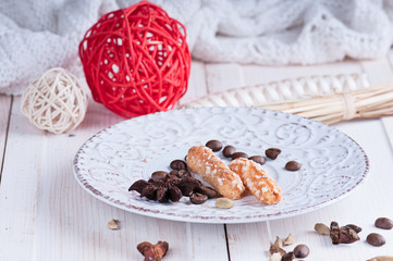 sugar cookies on a vintage saucer with ornament balls and spice anisetree and cardamom on a white surface