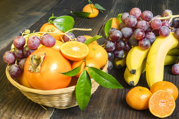 composition of fresh fruits in wicker baskets on a wooden background
